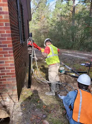 Steel push piers installed along foundation